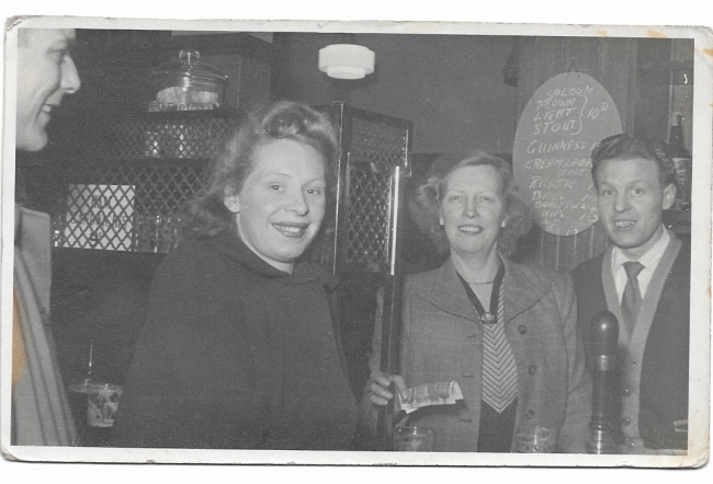 The Market House Pub in the Broadway, London Fields. It was taken in 1951. The landlady is May Salmon. Next to her is the piano player, come barman Herbie Taylor. Herbie was a friend of my parents who are standing this side of the bar