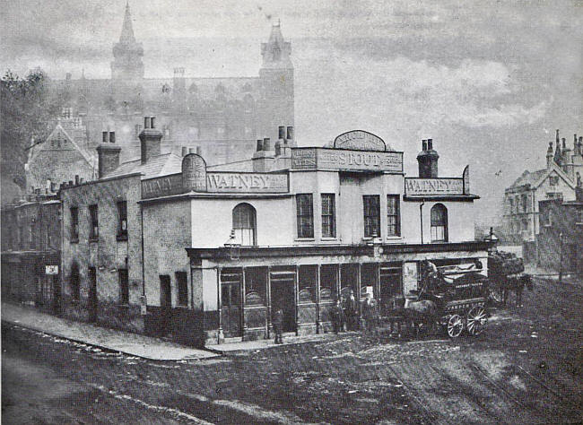 In 1885 this shows the previous Archway Tavern, on the same site, with the Whittington hospital in the background.